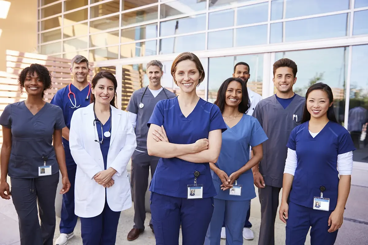 Team Healthcare Workers With Id Badges Outside Hospital